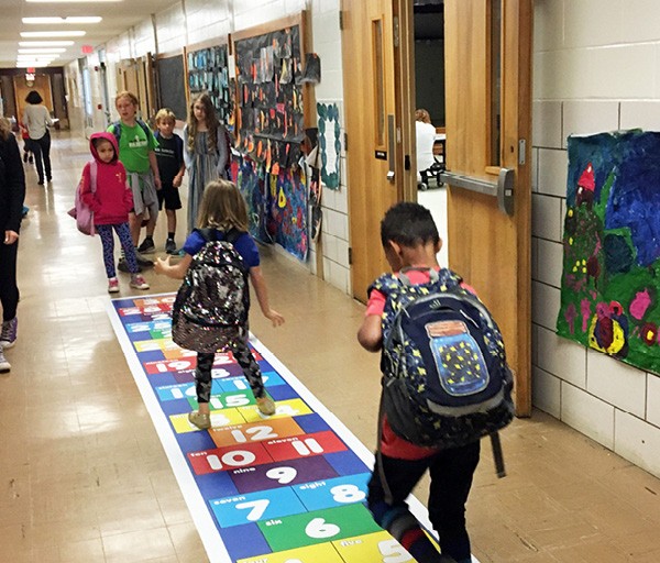 students in hallway on the hopscotch for threes kinesthetic material sticker