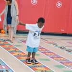 student jumping on skip counting by 3s mat