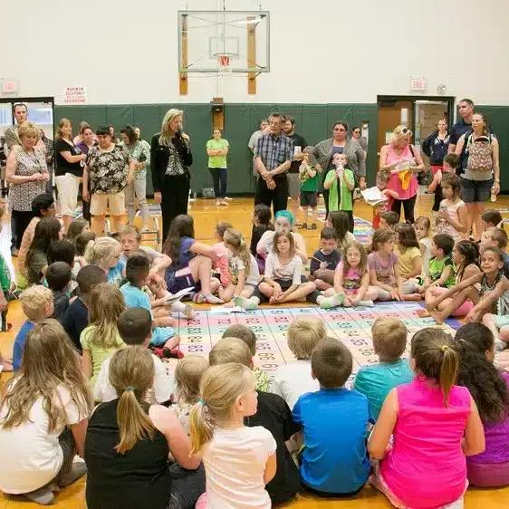 students sitting around mat - about us