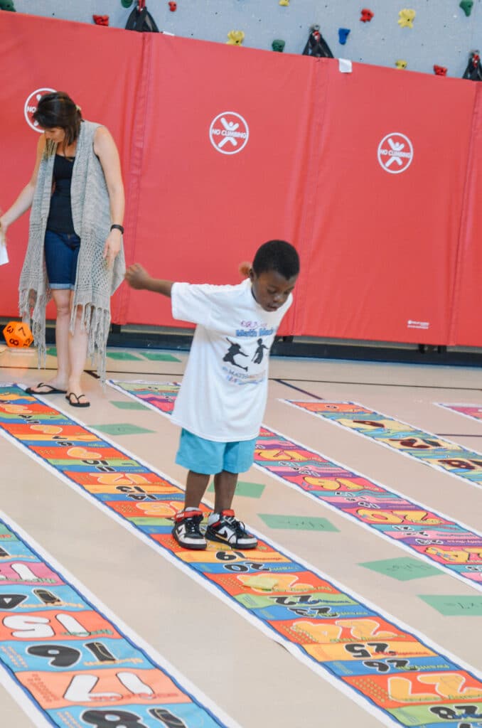 student jumping on skip counting by 3s mat